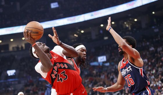 Toronto Raptors forward Pascal Siakam (43) shoots over Washington Wizards guard Spencer Dinwiddie (26) during first-half NBA basketball game action in Toronto, Sunday, Dec. 5, 2021. (Cole Burston/The Canadian Press via AP)