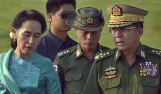 Aung San Suu Kyi, left, Myanmar&#39;s foreign minister and de facto leader, walks with Senior Gen. Min Aung Hlaing, right, commander-in-chief in the airport of capital Naypyitaw, Myanmar on May 6, 2016. A court in Myanmar sentenced the country’s ousted leader, Aung San Suu Kyi, to four years in prison on Monday, Dec. 6, 2021, after finding her guilty of incitement and violating coronavirus restrictions, a legal official said. (AP Photo/Aung Shine Oo, File)