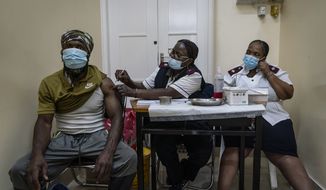 A man is vaccinated against COVID-19 at the Hillbrow Clinic in Johannesburg, South Africa, Monday Dec. 6, 2021. The new omicron variant appears to be driving a dramatic surge in South Africa, providing the world a glimpse of where the pandemic might be headed. (AP Photo/Shiraaz Mohamed)