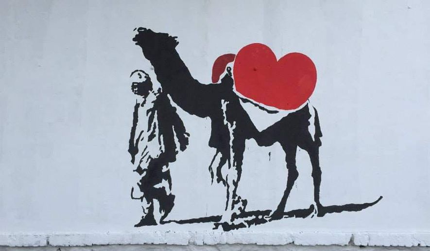 A political mural by the Kabul street art group ArtLords depicts a heart rather than a gun in an Afghan&#39;s camel saddlebag, one of more than 2,000 public artworks the Taliban have destroyed since taking over Afghanistan in August. Some refugees from the group recreated one of the murals at a live art show in Washington, D.C., on Saturday, Dec. 3. (ArtLords/Women for Afghan Women)