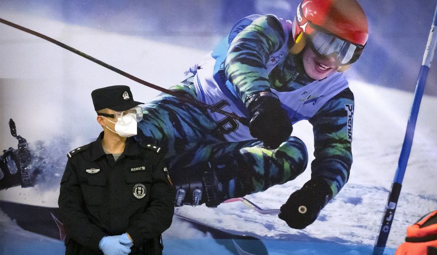 FILE - A police officer wearing a face mask and goggles to protect against COVID-19, stands near a poster of a skier on the wall at a train station in Zhangjiakou in northern China&#39;s Hebei Province, Friday, Nov. 26, 2021. China is threatening to take “firm countermeasures&amp;quot; if the U.S. proceeds with a diplomatic boycott of February&#39;s Beijing Winter Olympic Games. Foreign Ministry spokesperson Zhao Lijian on Monday accused U.S. politicians of grandstanding over the issue of not sending dignitaries to attend the events that China hopes will showcase its economic development. (AP Photo/Mark Schiefelbein, File)
