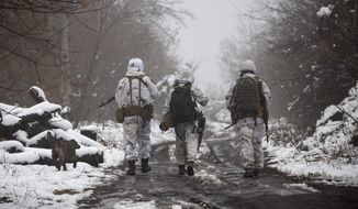 Ukrainian soldiers walks at the line of separation from pro-Russian rebels near Katerinivka, Donetsk region, Ukraine, Tuesday, Dec 7, 2021. The final portion of a $60 million U.S. security assistance package to Ukraine approved by President Biden is expected to arrive this week amid rising tensions with Moscow as hundreds of Russian troops continue massing along the border. (AP Photo/Andriy Dubchak)