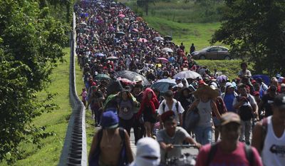 Migrants arrive in Villa Comaltitlan, Chiapas state, Mexico, Oct. 27, 2021, as they continue their journey through Mexico to the U.S. border. The Biden administration struck an agreement with Mexico to reinstate a Trump-era border policy next week that forces asylum-seekers to wait in Mexico for hearings in U.S. immigration court, U.S. officials said Thursday. (AP Photo/Marco Ugarte, File)