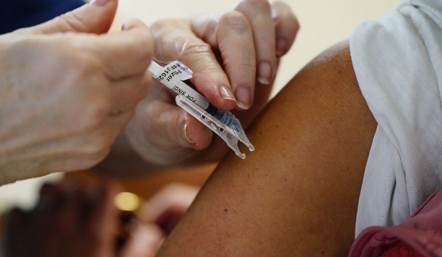 A health worker administers a dose of a Pfizer COVID-19 vaccine during a vaccination clinic at the Norristown Public Health Center in Norristown, Pa., Tuesday, Dec. 7, 2021. (AP Photo/Matt Rourke)