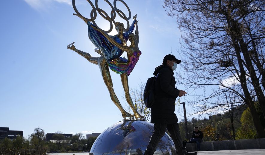 A visitor to the Shougang Park walks past the a sculpture for the Beijing Winter Olympics in Beijing, China, Tuesday, Nov. 9, 2021. China on Monday, Dec. 6, 2021, threatened to take &amp;quot;firm countermeasures&amp;quot; if the U.S. proceeds with a diplomatic boycott of February&#39;s Beijing Winter Olympic Games. (AP Photo/Ng Han Guan)