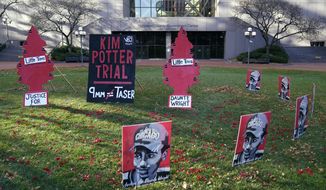 Posters stand on the south lawn Tuesday, Nov. 30, 2021, at the Hennepin County Government Center in Minneapolis where jury selection begins for former suburban Minneapolis police officer Kim Potter, who says she meant to grab her Taser instead of her handgun when she shot and killed motorist Daunte Wright. (AP Photo/Jim Mone)