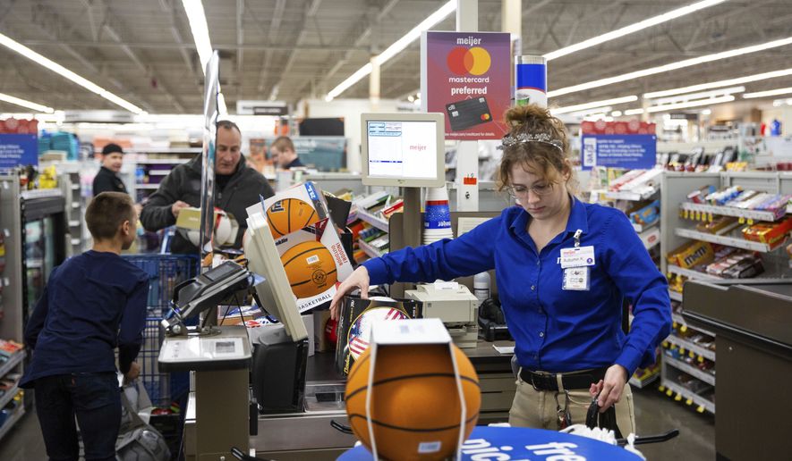 Meijer cashier Autumn Kilbourne rings up a cart full of sports balls as Warren County Sheriff Brett Hightower and his 9-year-old son Malachi continue to unload toys during the Bowling Green Fraternal Order of Police Lodge 13&#x27;s annual Shop with a Cop event at Meijer  in Bowling Green, Ky., on Tuesday, Dec. 7, 2021, to collect Christmas gifts for children at the Boys and Girls Club. (Grace Ramey/Daily News via AP)