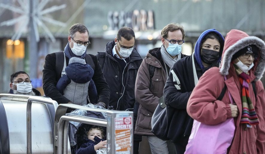 Commuters wearing face masks to protect against COVID-19 ride a escalator at La Defense business district in Paris, Wednesday, Dec. 8, 2021. The new potentially more contagious omicron variant of the coronavirus popped up in more European countries just days after being identified in South Africa, leaving governments around the world scrambling to stop the spread. (AP Photo/Michel Euler)