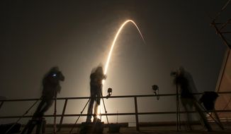 Photographers follow a SpaceX Falcon 9 rocket during a time exposure as it lifts off from Launch Complex 39A at the Kennedy Space Center in Cape Canaveral, Fla., Thursday, Dec. 9, 2021. The Falcon 9 will deploy into orbit NASA&#39;s Imaging X-ray Polarimetry Explorer (IXPE) spacecraft, an X-ray astronomy mission to study black holes and neutron stars.(AP Photo/John Raoux)
