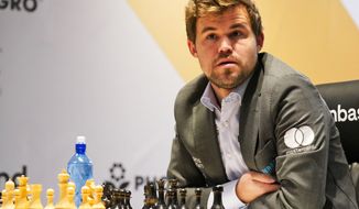 Magnus Carlsen of Norway competes during the FIDE World Championship at Dubai Expo 2020 in Dubai, United Arab Emirates, Friday, Dec. 10, 2021. (AP Photo/Jon Gambrell)