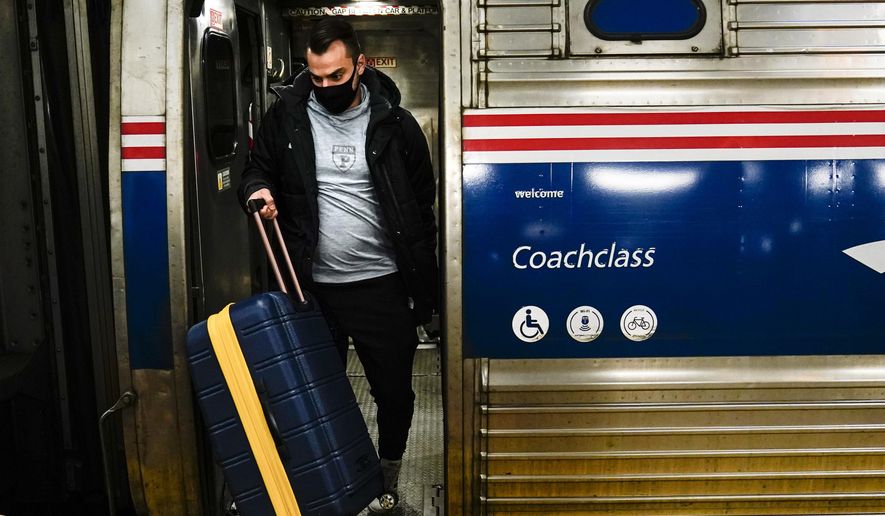 A traveler exits an Amtrak train ahead of the Thanksgiving Day holiday at 30th Street Station in Philadelphia, Wednesday, Nov. 24, 2021. (AP Photo/Matt Rourke, File)
