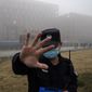 A security person moves journalists away from the Wuhan Institute of Virology after a World Health Organization team arrived for a field visit in Wuhan in China&#39;s Hubei province on Feb. 3, 2021. Nearly two years into the COVID-19 pandemic, the origin of the virus tormenting the world remains shrouded in mystery. (AP Photo/Ng Han Guan, File)