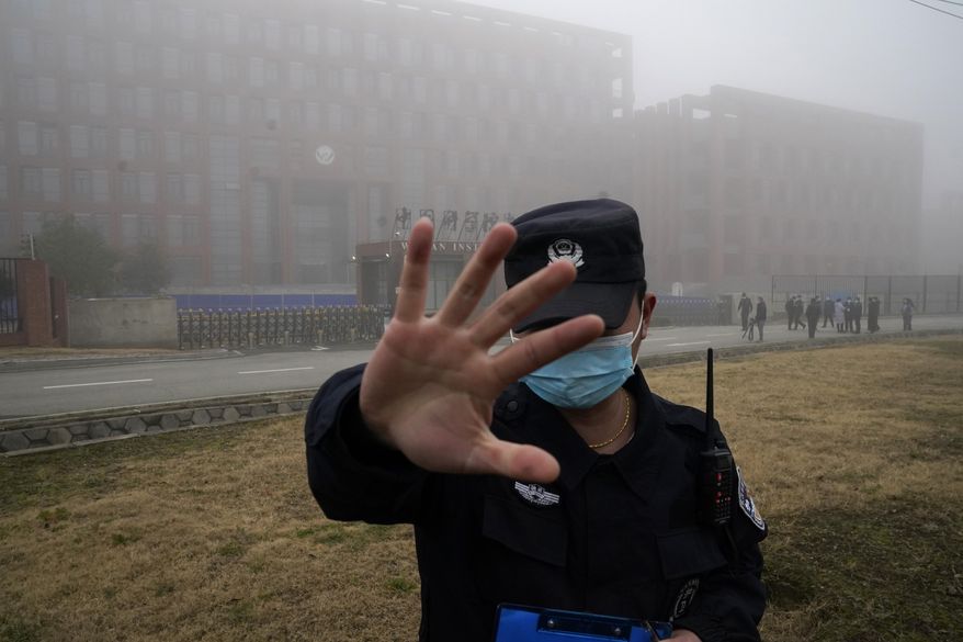 A security person moves journalists away from the Wuhan Institute of Virology after a World Health Organization team arrived for a field visit in Wuhan in China&#x27;s Hubei province on Feb. 3, 2021. Nearly two years into the COVID-19 pandemic, the origin of the virus tormenting the world remains shrouded in mystery. (AP Photo/Ng Han Guan, File)