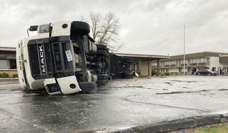 A large semi trailer is flipped over and pushed against a building in Bowling Green, Ky., on Saturday, Dec. 11, 2021. Tornadoes and severe weather caused catastrophic damage across multiple states late Friday, killing at least six people overnight as a storm system tore through a candle factory in Kentucky, an Amazon facility in Illinois and a nursing home in Arkansas. (AP Photo/Dylan T. Lovan)