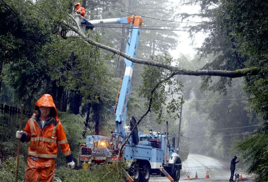 Pacific Gas & Electric crews work to clear a downed tree over Highway 9 north of Boulder Creek, Calif., on Jan. 8, 2017, in this file photo. A major storm is headed toward Northern California this weekend, promising to drop heavy snow in the Sierra Nevada and rain throughout the region. Forecasters say the storm is on track to hit coastal areas north of San Francisco, on the night of Saturday, Dec. 11, 2021, and bring light rain. PG&E is sending crews to clear vegetation away from power lines to reduce the chance of power outages. (Kevin Johnson/The Santa Cruz Sentinel via AP, File) **FILE**