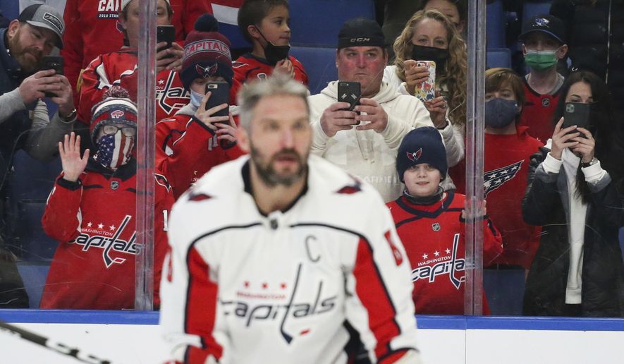 Fans watch and take photos as Washington Capitals left wing Alex Ovechkin (8) warms up before an NHL hockey game against the Buffalo Sabres on Saturday, Dec. 11, 2021, in Buffalo, N.Y. (AP Photo/Joshua Bessex)