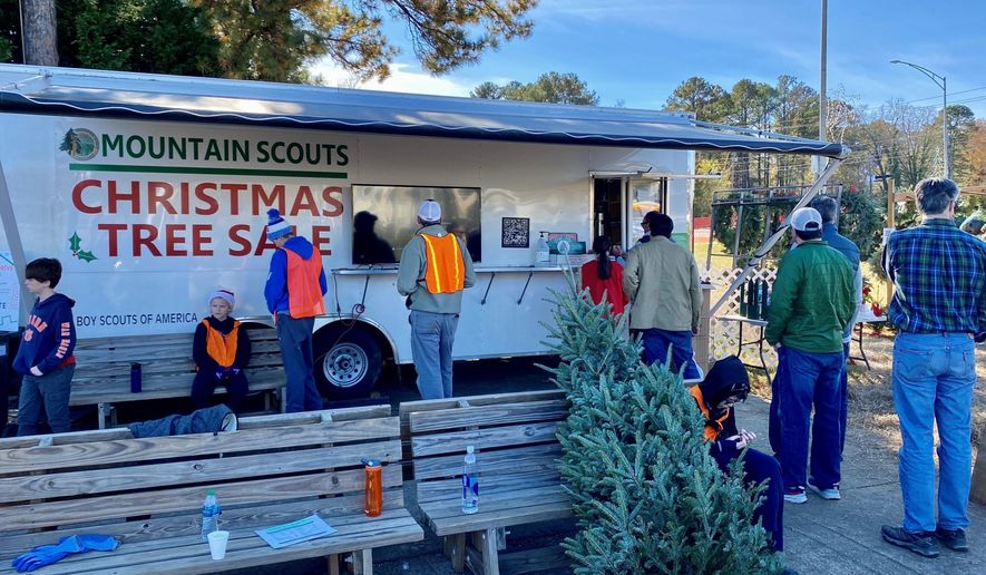 People stand on line to buy Christmas trees at the annual Mountain Scouts Christmas Tree Sale,  in Vestavia Hills, Ala. on Nov. 29, 2021.  (Bob Carlton/The Birmingham News via AP)