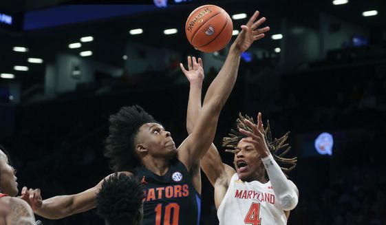 Maryland&#39;s Fatts Russell (4) has the ball knocked away by Florida&#39;s Elijah Kennedy (10) during the first half of an NCAA college basketball game Sunday, Dec. 12, 2021, in New York. (AP Photo/Jason DeCrow)