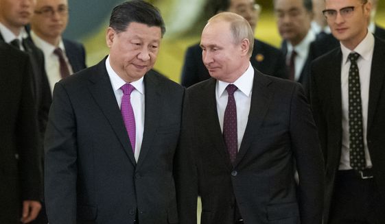Chinese President Xi Jinping, center left, and Russian President Vladimir Putin, center right, enter a hall for talks in the Kremlin in Moscow, Russia, June 5, 2019. (AP Photo/Alexander Zemlianichenko, Pool, File)