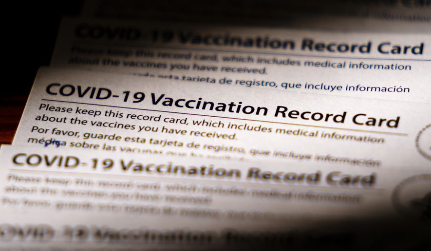 Shown are COVID-19 vaccination record cards in Glenside, Pa., Monday, Dec. 13, 2021. (AP Photo/Matt Rourke) ** FILE **