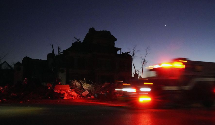 An emergency vehicle passes the damaged Graves County Courthouse Sunday, Dec. 12, 2021, in Mayfield, Ky. Tornadoes and severe weather caused catastrophic damage across several states Friday, killing multiple people. (AP Photo/Mark Humphrey)