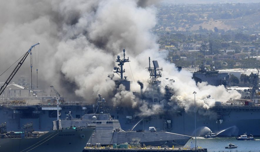 In this July 12, 2020, file photo, smoke rises from the USS Bonhomme Richard after an explosion and fire on board the ship at Naval Base San Diego. A sailor is getting a first court hearing Monday at the U.S. Navy’s base in San Diego, California over allegations that he started the fire in July 2020 that resulted in the total loss of the USS Bonhomme Richard, an amphibious assault ship. (AP Photo/Denis Poroy, File)