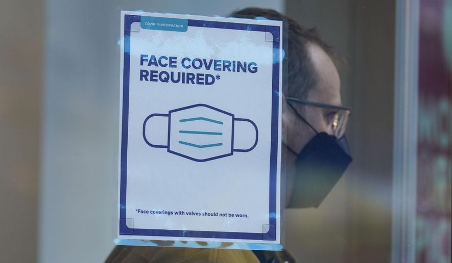 A sign reminds customers that masks are required in their store in New York, Monday, Dec. 13, 2021. (AP Photo/Seth Wenig) **FILE**