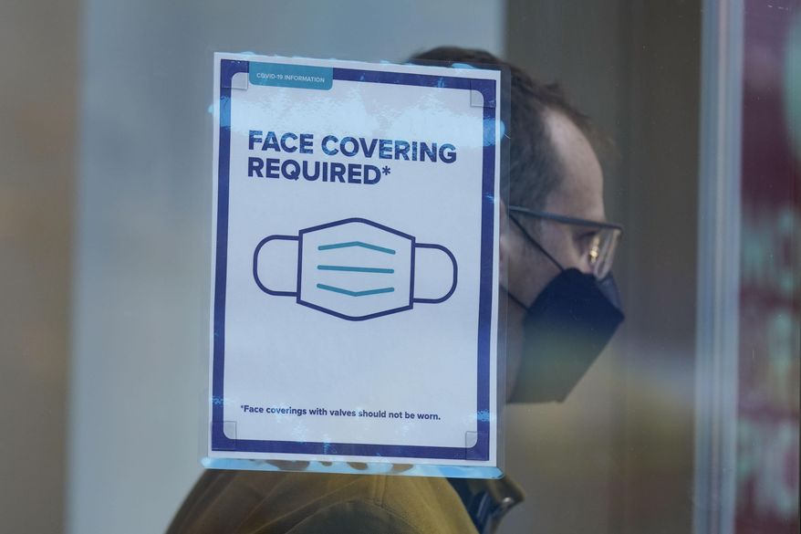 A sign reminds customers that masks are required in their store in New York, Monday, Dec. 13, 2021. (AP Photo/Seth Wenig) **FILE**