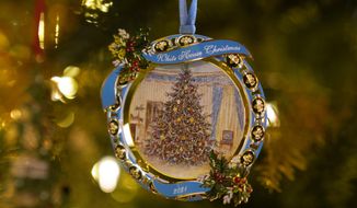 The White House Historical Association&#39;s 2021 Christmas tree ornament that honors President Lyndon Johnson hangs on a tree in the St. Regis Hotel in Washington, Friday, Dec. 10, 2021. The 2021 official White House ornament, the 41st in the series, honors President Johnson with its reproduction of a painting of the Blue Room tree the family had in December 1967. (AP Photo/Susan Walsh)