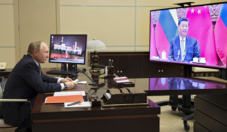 Russian President Vladimir Putin talks with Chinese President Xi Jinping via videoconference at the Novo-Ogaryovo residence outside Moscow, Russia, Wednesday, Dec. 15, 2021. Chinese President Xi Jinping supported Russian President Vladimir Putin in his push to get Western security guarantees precluding NATO&#x27;s eastward expansion, the Kremlin said Wednesday after the two leaders held a virtual summit. Putin and Xi spoke as Moscow faces heightened tensions with the West over a Russian troop buildup near Ukraine&#x27;s border. (Mikhail Metzel, Sputnik, Kremlin Pool Photo via AP)