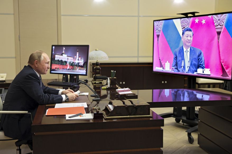 Russian President Vladimir Putin talks with Chinese President Xi Jinping via videoconference at the Novo-Ogaryovo residence outside Moscow, Russia, Wednesday, Dec. 15, 2021. Chinese President Xi Jinping supported Russian President Vladimir Putin in his push to get Western security guarantees precluding NATO&#39;s eastward expansion, the Kremlin said Wednesday after the two leaders held a virtual summit. Putin and Xi spoke as Moscow faces heightened tensions with the West over a Russian troop buildup near Ukraine&#39;s border. (Mikhail Metzel, Sputnik, Kremlin Pool Photo via AP)