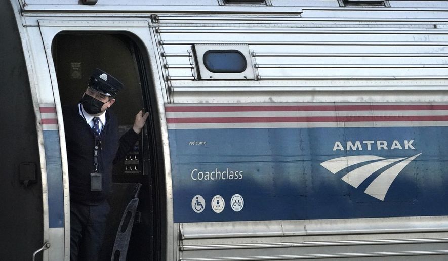 In this file photo, a conductor makes sure all is clear as the Amtrak Downeaster passenger train pulls out of the station, Tuesday, Dec. 14, 2021, in Freeport, Maine. (AP Photo/Robert F. Bukaty) **FILE**