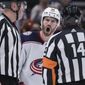 Columbus Blue Jackets&#39; Boone Jenner, back, protests to referee Trevor Hanson, right, after a penalty was called against Andrew Peeke during the third period of an NHL hockey game Tuesday, Dec. 14, 2021 in Vancouver, British Columbia. (Darryl Dyck/The Canadian Press via AP)