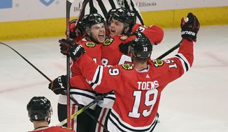 Chicago Blackhawks defenseman Riley Stillman, left, celebrates with right wing MacKenzie Entwistle, center, left wing Brandon Hagel, back, and center Jonathan Toews (19), after Entwistle scored during the second period of an NHL hockey game against the Washington Capitals, Wednesday, Dec. 15, 2021, in Chicago. (AP Photo/Matt Marton)