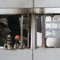 Firefighters stand on a floor at a building where a fire broke out in Osaka, western Japan Friday, Dec. 17, 2021. Japan&#39;s NHK says a fire broke out in the building and dozens of people were feared dead. (Kyodo News via AP)