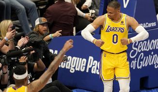 Los Angeles Lakers&#39; Russell Westbrook (0) celebrates after sinking a basket as fans look on in the second half of an NBA basketball game in Dallas, Wednesday, Dec. 15, 2021. (AP Photo/Tony Gutierrez)