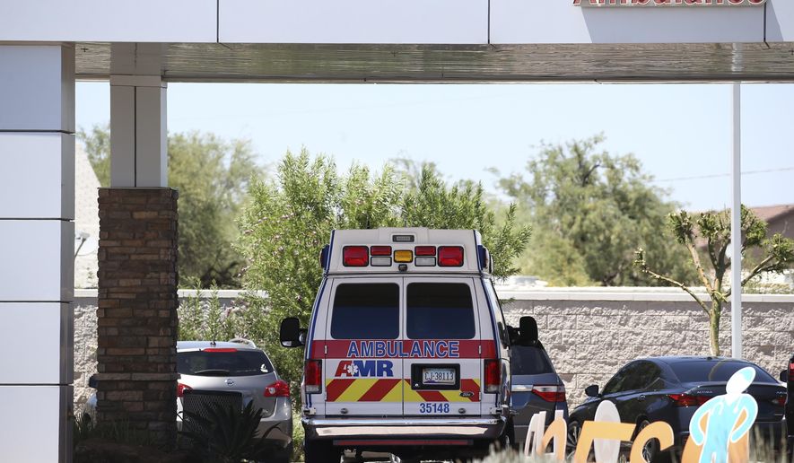 FILE - In this June 10, 2020, file photo, an ambulance is parked at Arizona General Hospital in Laveen, Ariz. Arizona is continuing to see slight downward trends with coronavirus hospitalizations as officials find more related deaths. Arizona is committing millions of dollars and asking the federal government for extra help as hospitals face a growing strain from rising COVID-19 caseloads and warn they are nearing their limits. (AP Photo/Ross D. Franklin, File)