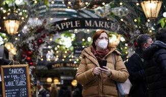 A woman wears a face mask as she walks in Covent Garden market, in London, Thursday, Dec. 16, 2021. The U.K. recorded the highest number of confirmed new COVID-19 infections Wednesday since the pandemic began, and England&#39;s chief medical officer warned the situation is likely to get worse as the omicron variant drives a new wave of illness during the Christmas holidays. The U.K. recorded 78,610 new infections on Wednesday, 16% higher than the previous record set in January. (AP Photo/Alberto Pezzali)