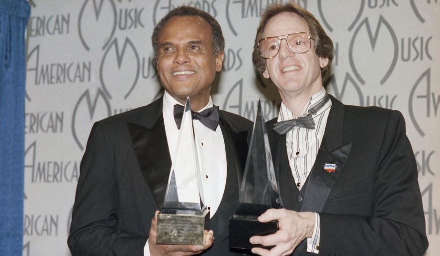 FILE - Singer Harry Belafonte and Ken Kragen display their special awards presented to them in Los Angeles, on Jan. 28, 1986, during the 13th annual American Music Awards for their efforts in the &quot;USA For Africa&quot; project and the hit song &quot;We Are The World.&quot; Kragen, a top entertainment producer, manager and philanthropist who turned to such clients as Lionel Richie and Kenny Rogers in helping to organize the 1985 all-star charity single “We Are the World,” has died at age 85. Kragen died Tuesday, Dec. 14, 2021, of natural causes at his home in Los Angeles, according to a statement released by his family. (AP Photo/Reed Saxon, File)