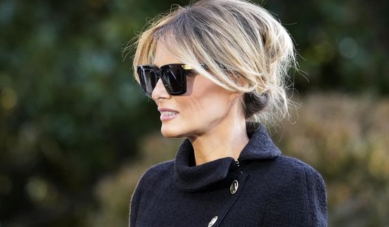 First Lady Melania Trump listens as President Donald Trump speaks with reporters as he walks to board Marine One on the South Lawn of the White House, Wednesday, Jan. 20, 2021, in Washington. The former first lady launched a venture this week selling non-fungible tokens that must be paid for with Solan cryptocurrency, currently valued around $180 each. Trump said she will release NFTs “in regular intervals” on her website, with a portion of the proceeds going to foster children. (AP Photo/Alex Brandon, File)