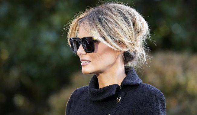 First Lady Melania Trump listens as President Donald Trump speaks with reporters as he walks to board Marine One on the South Lawn of the White House, Wednesday, Jan. 20, 2021, in Washington. The former first lady launched a venture this week selling non-fungible tokens that must be paid for with Solan cryptocurrency, currently valued around $180 each. Trump said she will release NFTs “in regular intervals” on her website, with a portion of the proceeds going to foster children. (AP Photo/Alex Brandon, File)
