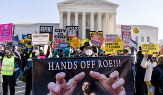 FILE - Stephen Parlato of Boulder, Colo., holds a sign that reads &amp;quot;Hands Off Roe!!!&amp;quot; as abortion rights advocates and anti-abortion protesters demonstrate in front of the U.S. Supreme Court, Dec. 1, 2021, in Washington, as the court hears arguments in a case from Mississippi, where a 2018 law would ban abortions after 15 weeks of pregnancy, well before viability. As 2021 comes to a close, Roe v. Wade — the historic 1973 Supreme Court ruling establishing a nationwide right to abortion — is imperiled as never before. (AP Photo/Andrew Harnik, File)