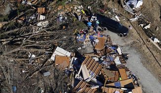 In this aerial photo, people sift through debris of a destroyed home in the aftermath of tornadoes that tore through the region, in Dresden, Tenn., Sunday, Dec. 12, 2021. (AP Photo/Gerald Herbert)