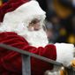 A fam dressed as Santa Claus watches during the second half of an NFL football game between the Pittsburgh Steelers and the Tennessee Titans, Sunday, Dec. 19, 2021, in Pittsburgh. (AP Photo/Don Wright)