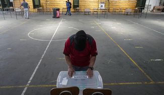 Electoral workers prepare a school to be a polling station for the presidential run-off election in Santiago, Chile, Friday, Dec. 17, 2021. Chile will hold a presidential run-off election on Dec. 19. (AP Photo/Esteban Felix)