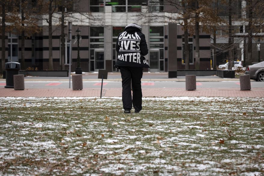 A demonstrator wears a Black Lives Matter jacket outside of the Hennepin County Courthouse during the trial of former Brooklyn Center police Officer Kim Potter, Friday Dec. 17, 2021, in Minneapolis. Potter, who is white, is charged with first- and second-degree manslaughter in the shooting of Daunte Wright, a Black motorist, in the suburb of Brooklyn Center. Potter has said she meant to use her Taser – but grabbed her handgun instead – after Wright tried to drive away as officers were trying to arrest him. (AP Photo/Christian Monterrosa) **FILE**
