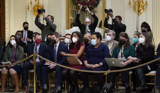 Members of the White House press corps listen as President Joe Biden speaks about the COVID-19 response and vaccinations, Tuesday, Dec. 21, 2021, in the State Dining Room of the White House in Washington. (AP Photo/Patrick Semansky)
