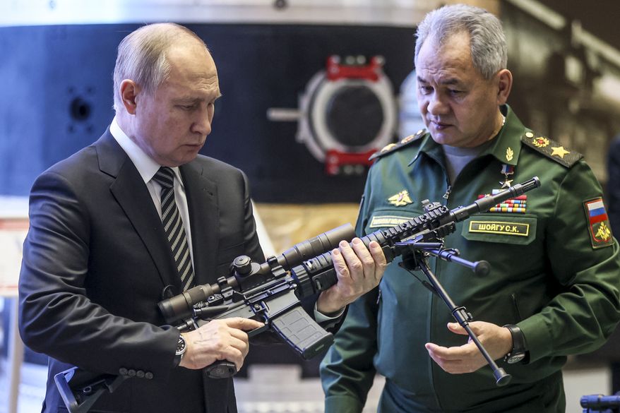 Russian President Vladimir Putin, left, and Russian Defense Minister Sergei Shoigu visit an military exhibition after attending an extended meeting of the Russian Defense Ministry Board at the National Defense Control Center in Moscow, Russia, Tuesday, Dec. 21, 2021. The Russian president on Tuesday reiterated the demand for guarantees from the U.S. and its allies that NATO will not expand eastward, blaming the West for current tensions in Europe. (Mikhail Metzel, Sputnik, Kremlin Pool Photo via AP)