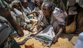 An Ethiopian woman argues with others over the allocation of yellow split peas distributed by the Relief Society of Tigray in the town of Agula, in the Tigray region of northern Ethiopia, on May 8, 2021. In war-torn Tigray, it is not just that people are starving; it is that many are being starved, The Associated Press found. (AP Photo/Ben Curtis) ** FILE **