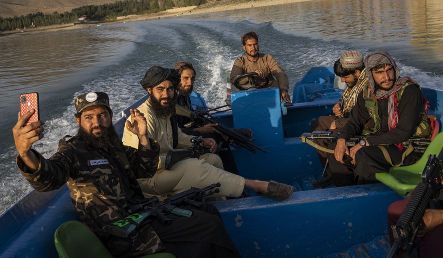 Taliban fighters ride in a boat in the Qargha dam outside Kabul, Afghanistan, on Sept. 24, 2021. (AP Photo/Bernat Armangue)